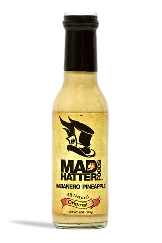 A bottle of Mad Hatter Original Sauce with a label featuring a pineapple and text that specifies the flavor as Habanero Pineapple and marks it as All Natural.